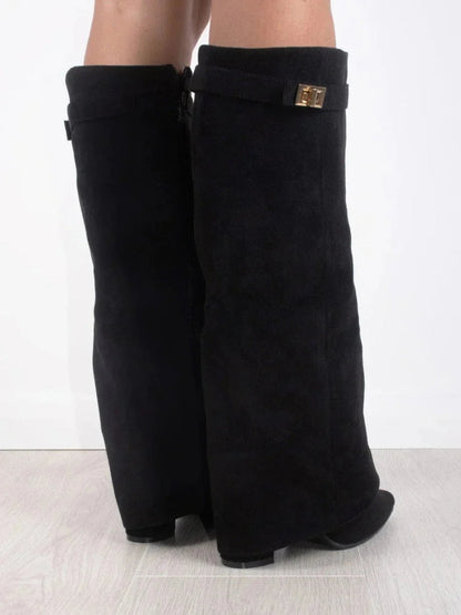 Bottes en suède noir pour femme, avec détails métalliques et design classique.