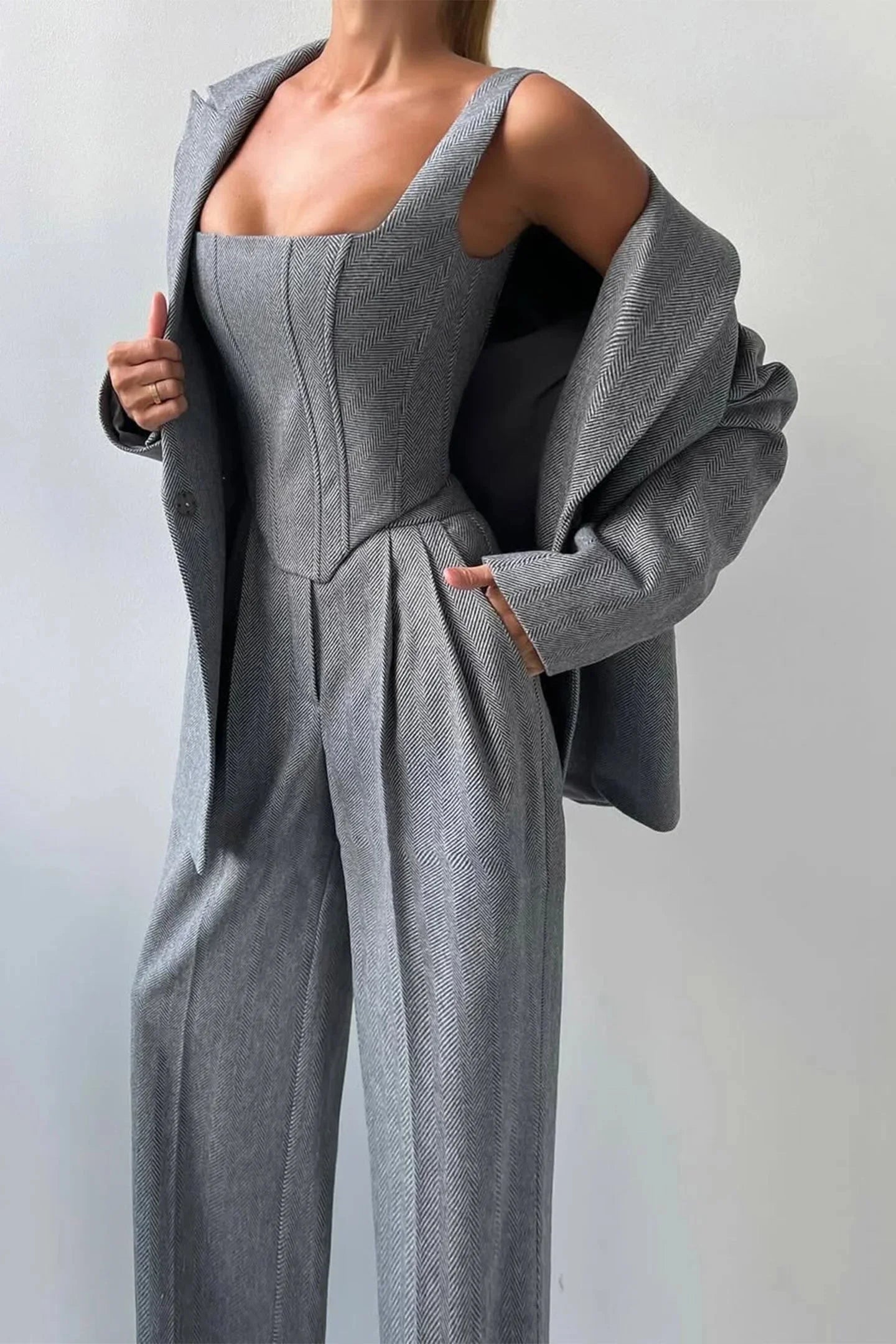 Ensemble femme trois pièces rose avec haut ajusté et coupe cintrée.