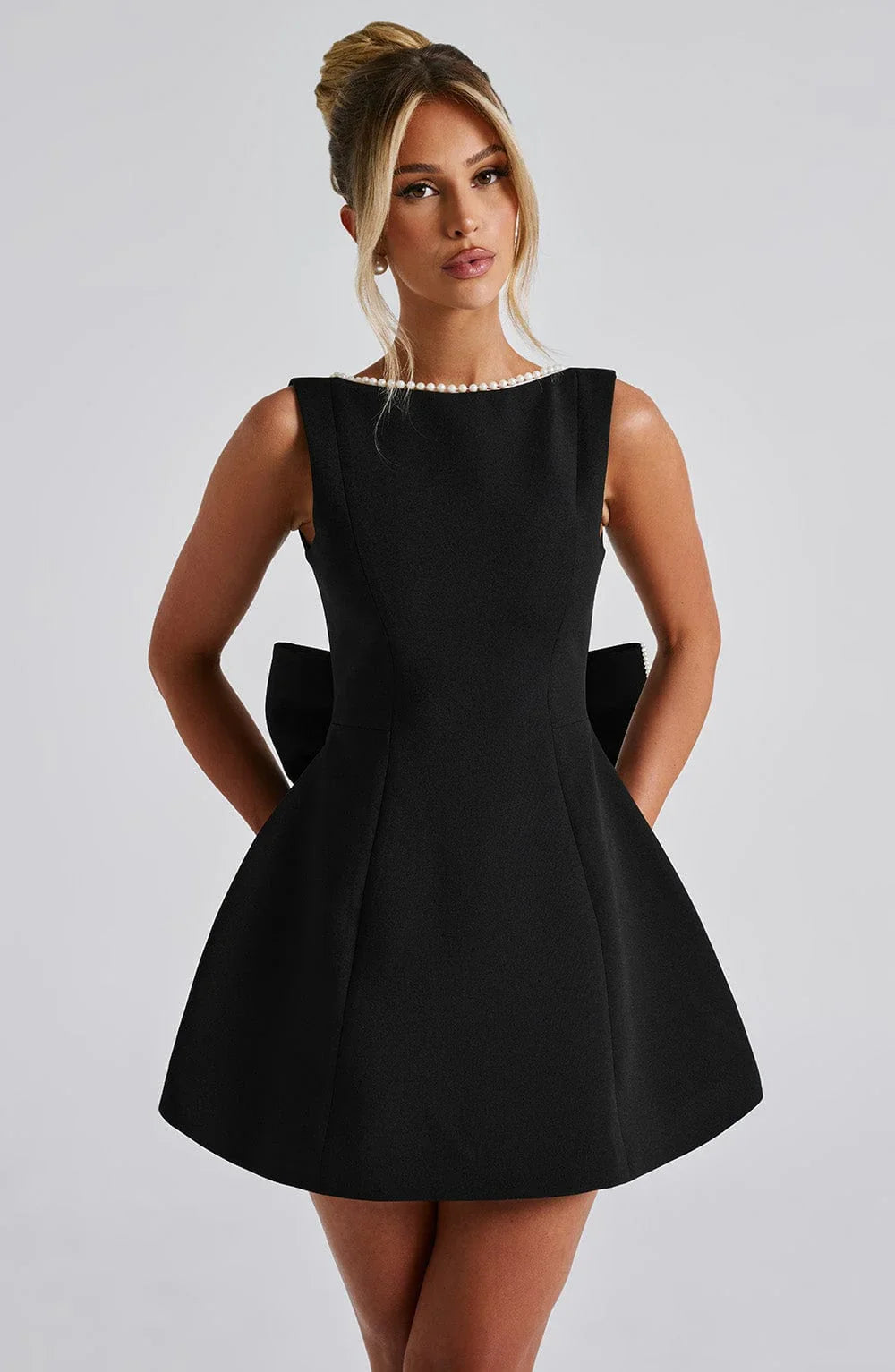 Robe courte femme en tissu léger avec nœud décoratif au dos et détails élégants, idéale pour les occasions décontractées.