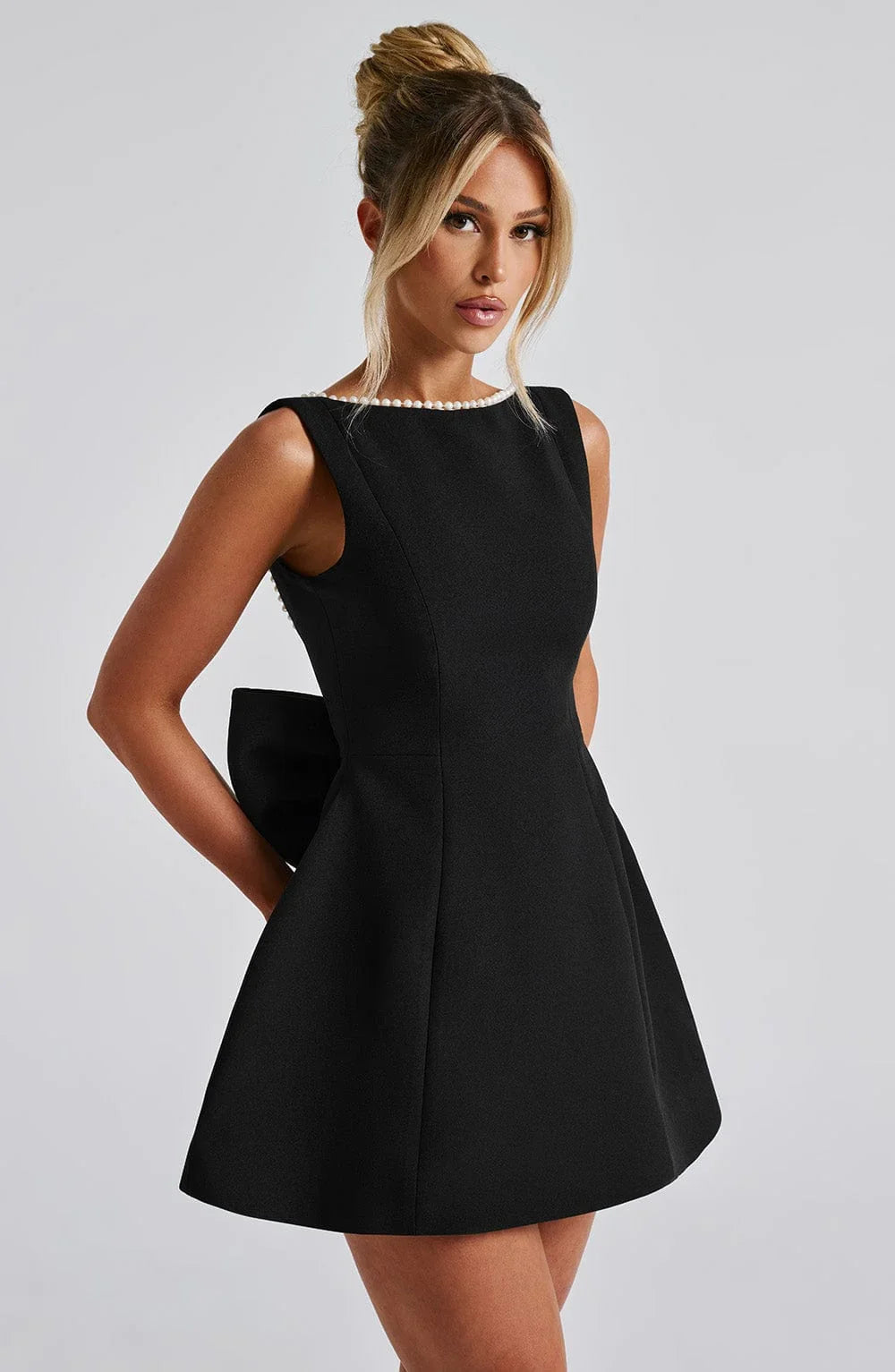 Robe courte femme en coton, avec nœud décoratif au dos et coupe ajustée, parfaite pour un look décontracté.