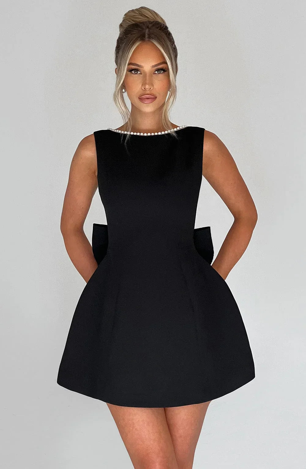 Robe courte femme en tissu léger avec nœud décoratif au dos, parfaite pour les journées d'été décontractées.