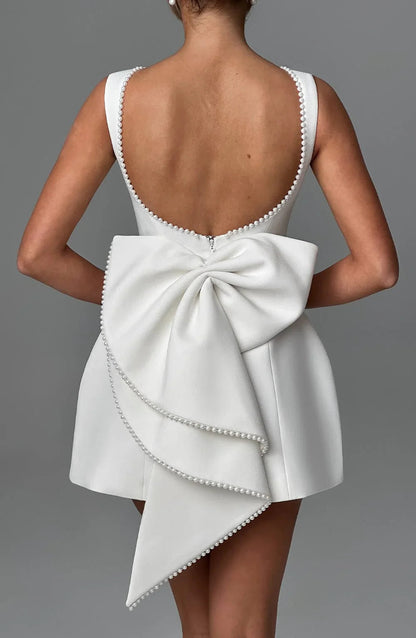 Robe courte femme en coton léger, avec un nœud décoratif au dos et des manches courtes pour un style élégant.