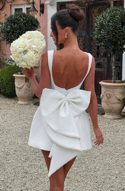 Robe courte femme en tissu léger, avec nœud décoratif au dos et coupe élégante, parfaite pour les occasions décontractées.