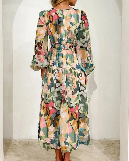 Robe longue fleurie en tissu fluide, col en V et manches longues, avec taille cintrée, parfaite pour un mariage au printemps.