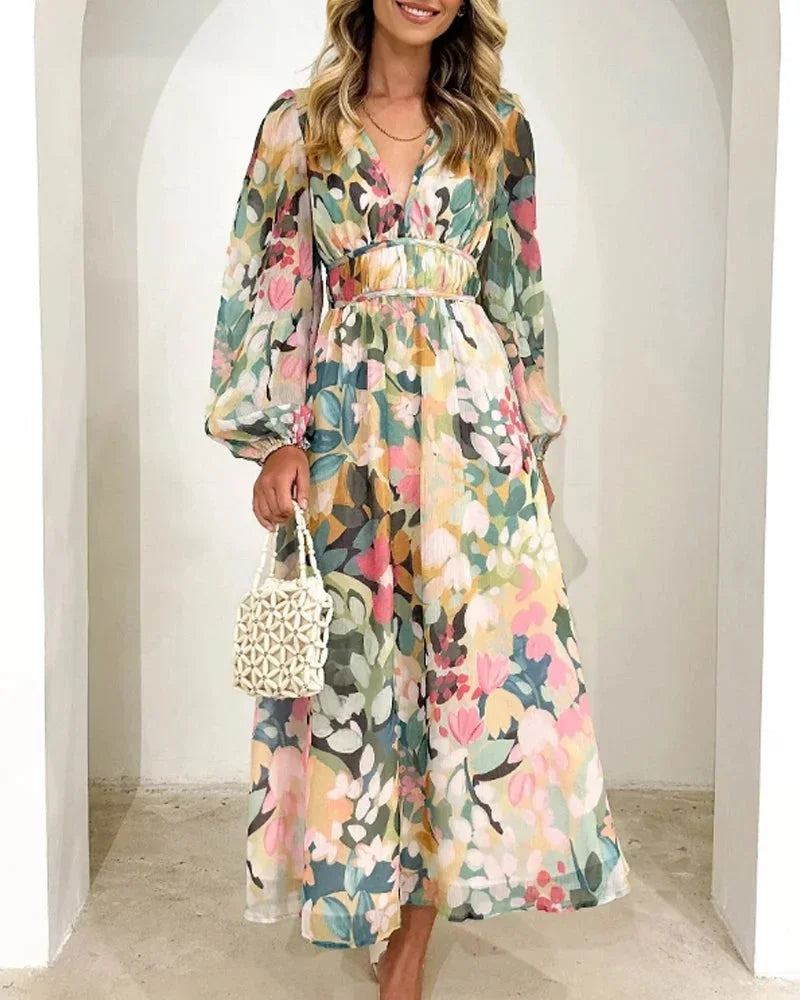 Robe longue fleurie à manches longues, col en V, tissu fluide, taille cintrée, idéale pour un mariage au printemps.