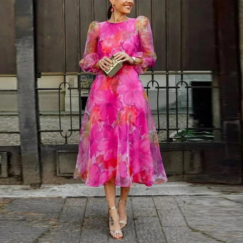 Robe midi à fleurs avec manches transparentes en tissu léger, idéale pour les invités de mariage.