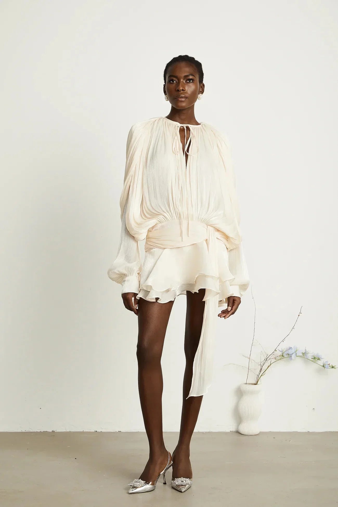 Robe fluide en satin avec manches longues et nœuds, parfaite pour les soirées, disponible en différentes couleurs.