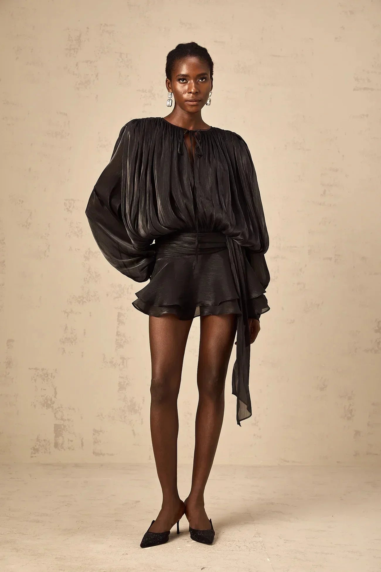Robe courte satinée avec nœuds aux manches longues, fluide et élégante, disponible en plusieurs couleurs.
