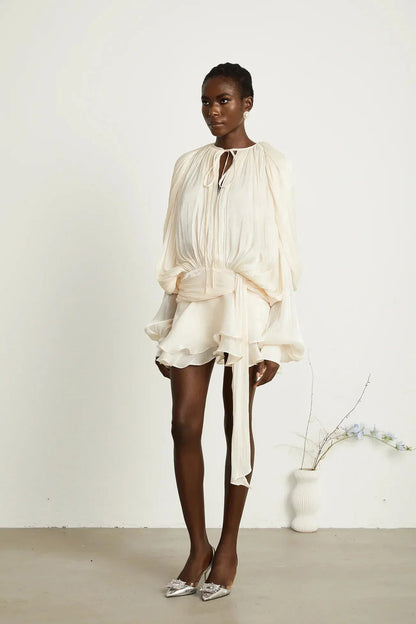 Robe courte satinée fluide avec nœuds, manches longues, idéale pour soirées, disponible en plusieurs couleurs élégantes.